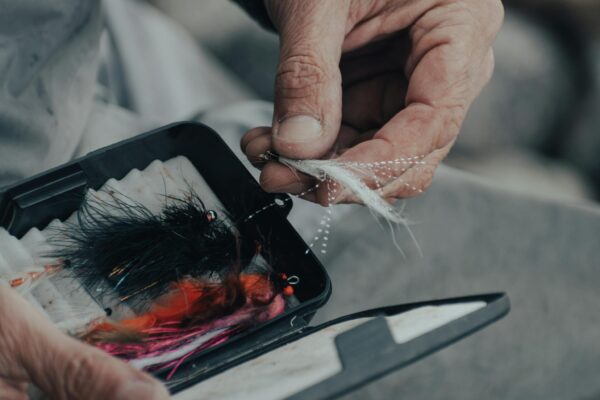 A Fisherman Choosing a Bait for His Fishing Rod